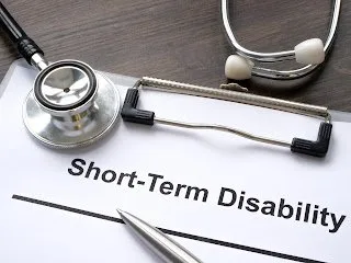 Blank short-term disability claim form on a desk with a stethoscope and pen