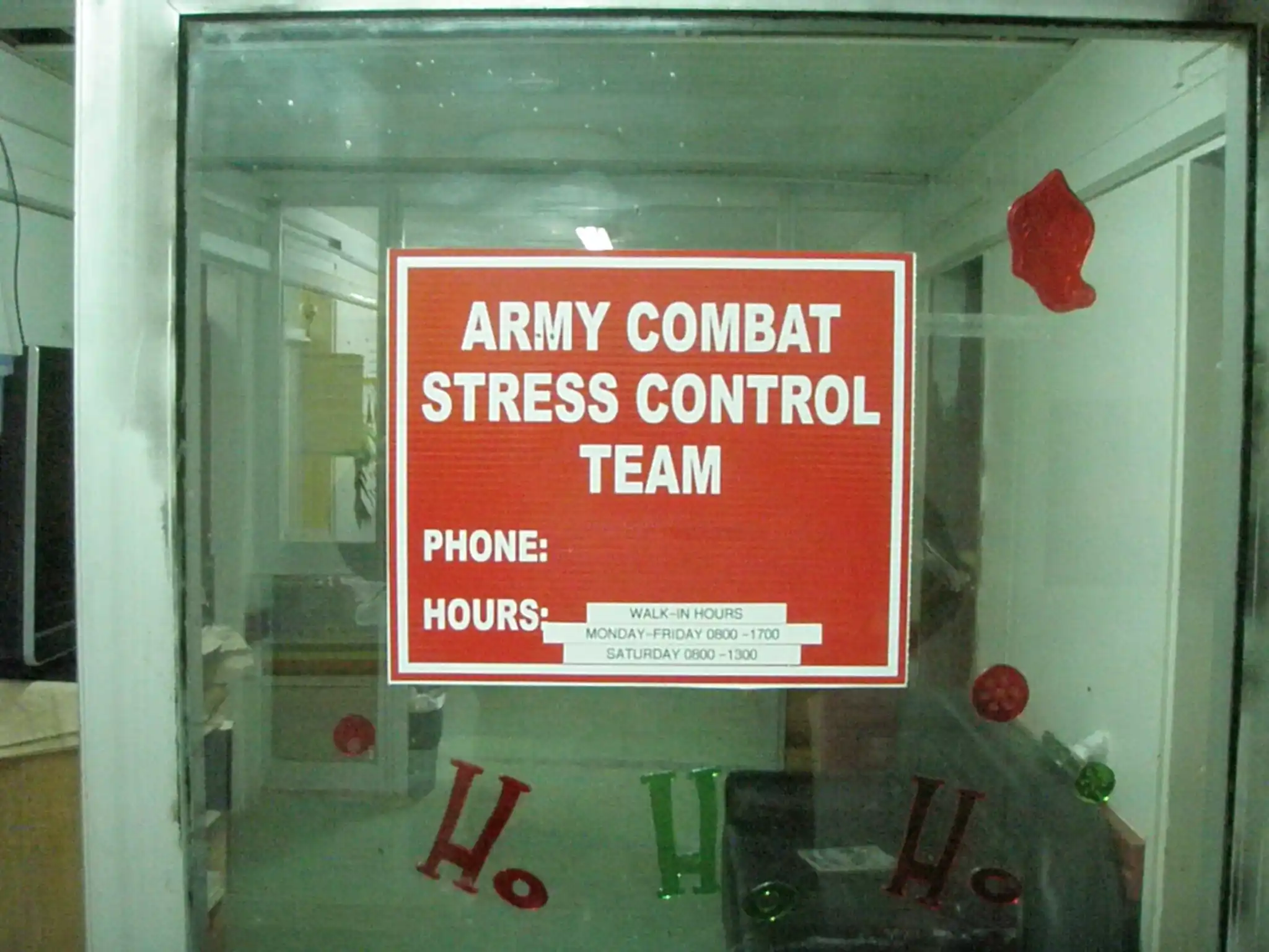 A red Army Combat Stress Control Team sign posted with walk-in hours in a glass entryway.