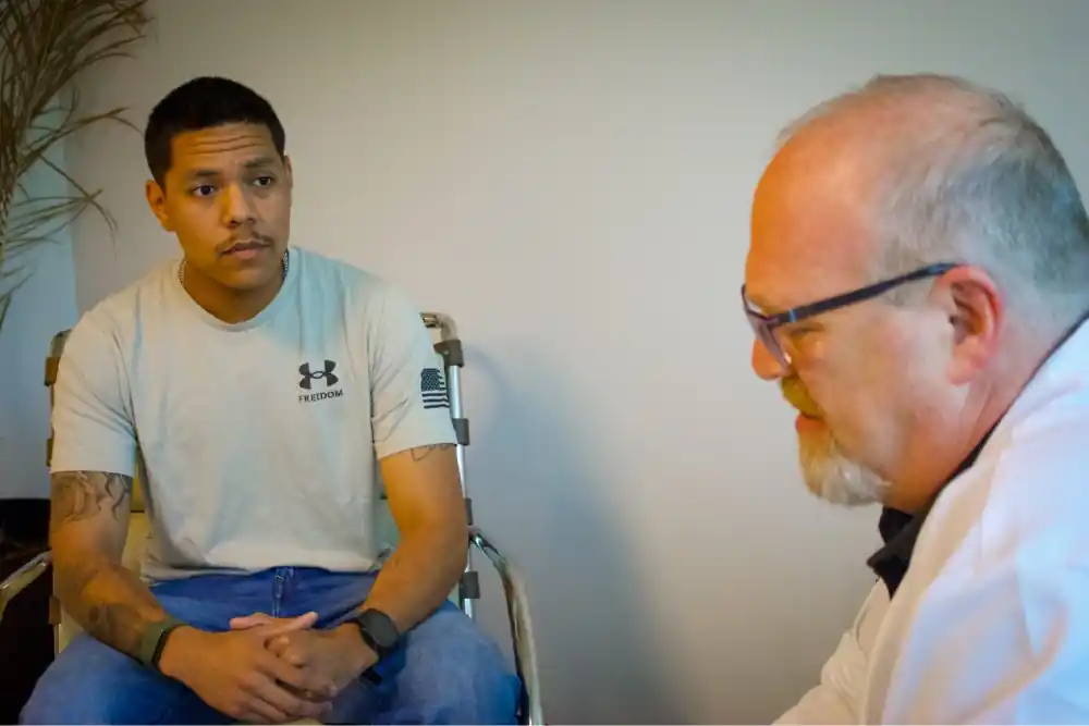 Dr. Jerald Block listening to a young service member during a consultation.